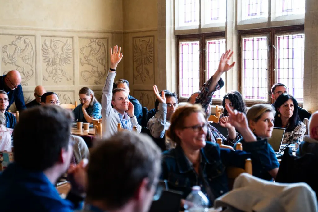 Climate Change and History Research Initiative 2026 Annual Colloquium - attendees rising hands